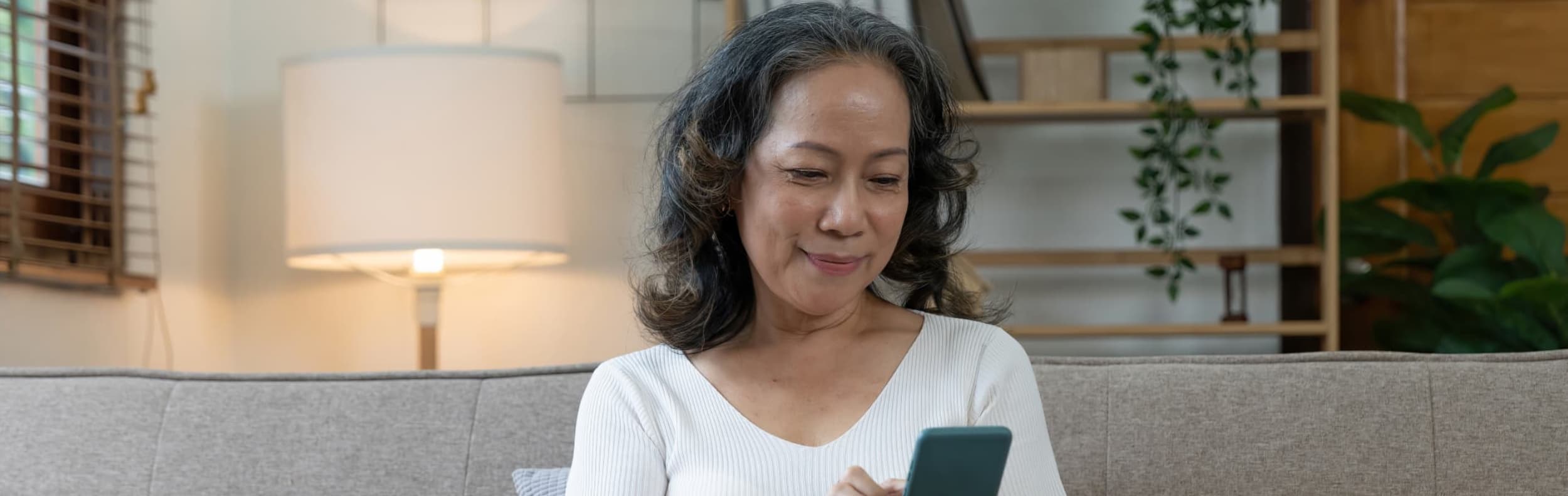 woman sitting on couch using phone